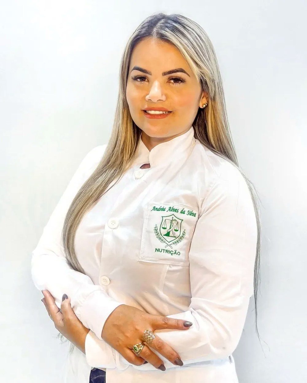 Andréa Alves, nutricionista, de jaleco branco com o emblema Nutrição bordado